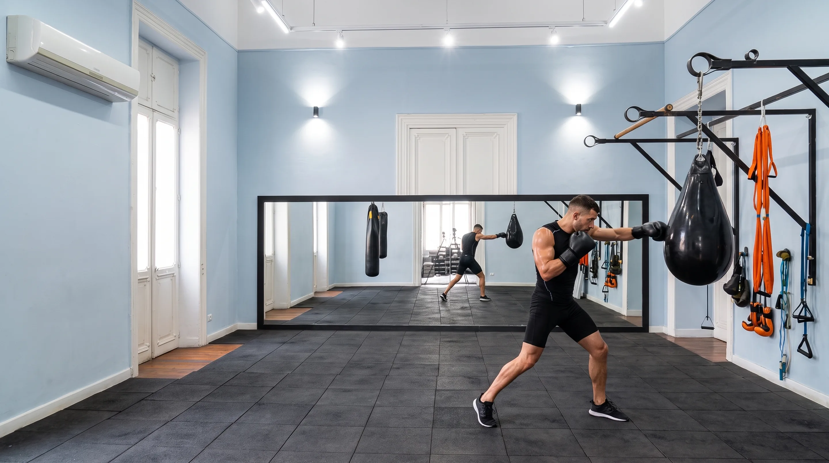 A member working the punch bag in the mirrored Canopus training room